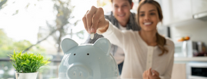 Couple adding money to a piggy bank